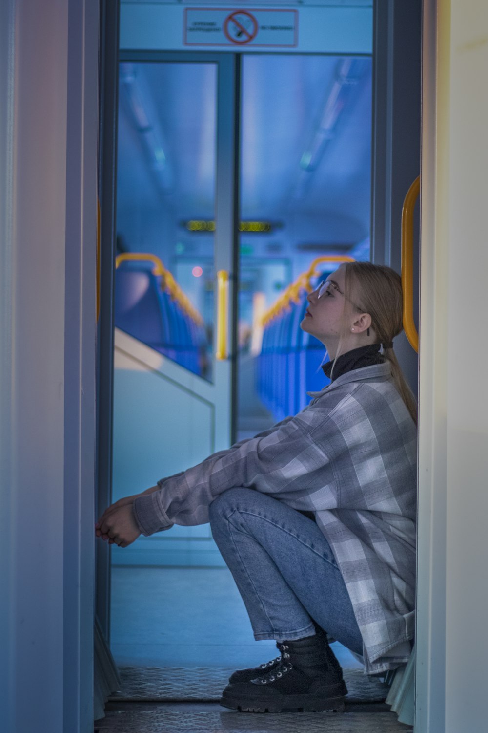 a woman sitting on the floor in front of a door