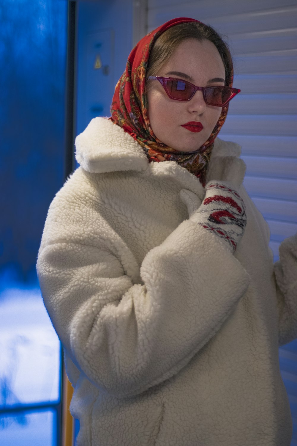 a woman in a white coat and red scarf