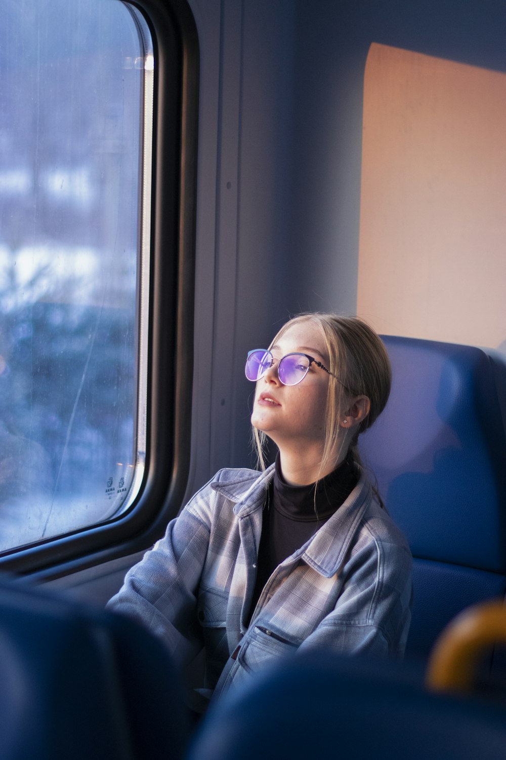 a woman sitting on a train looking out the window