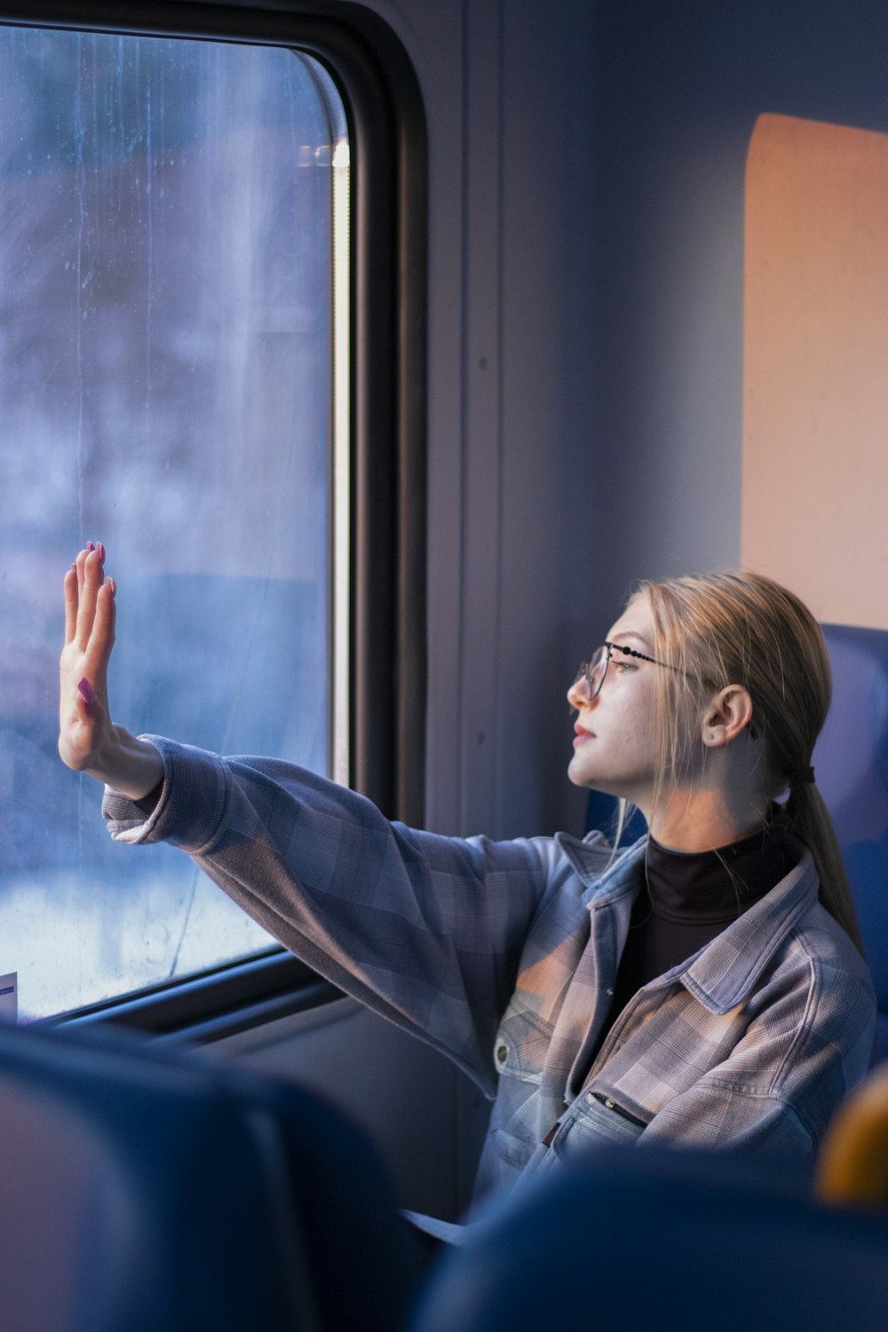 a woman looking out a window on a train