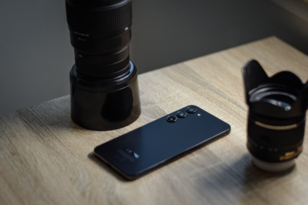a camera and a cell phone sitting on a table