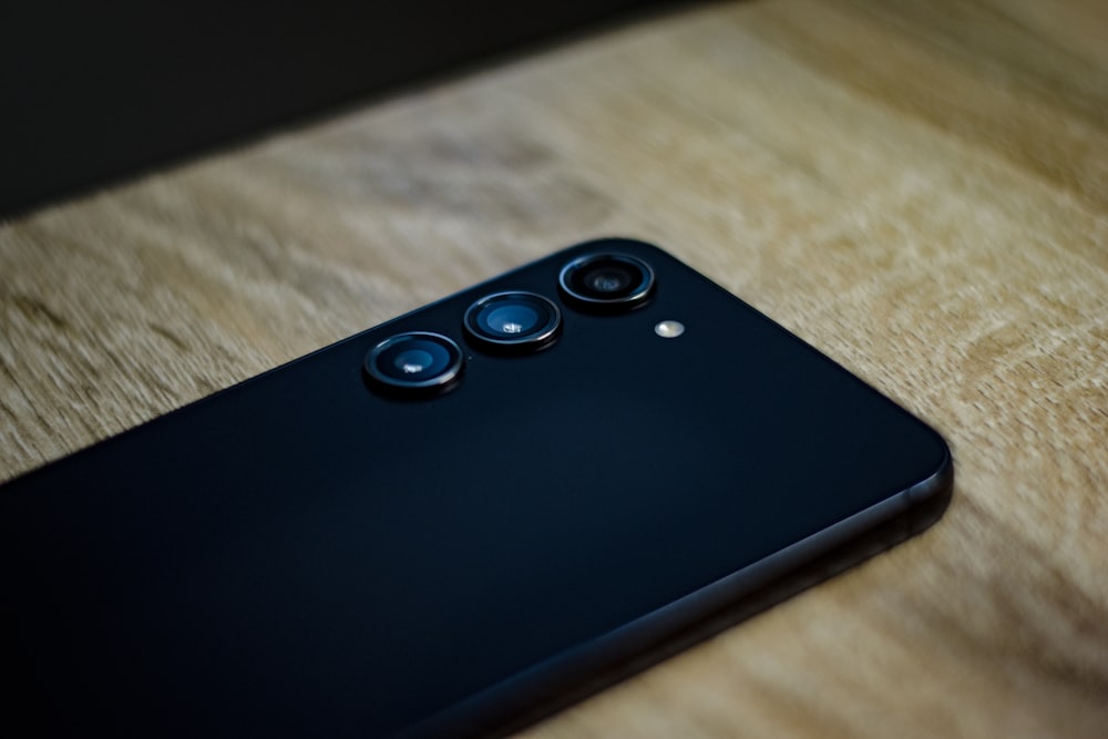 a close up of a cell phone on a wooden table