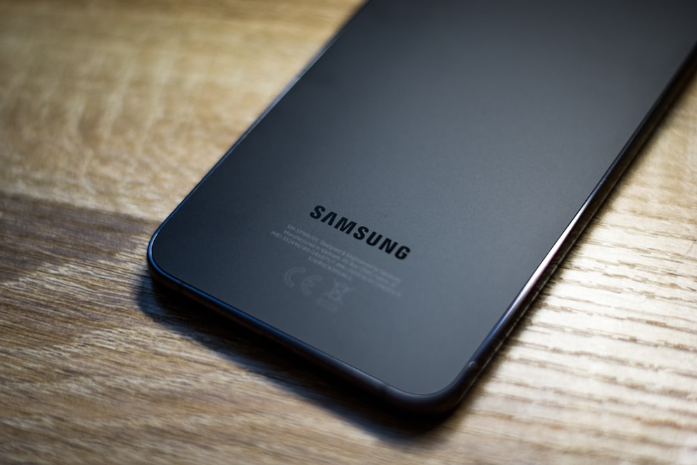 a close up of a samsung phone on a wooden table