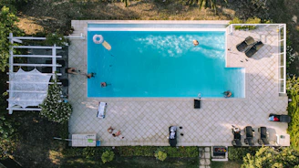Drone footage capturing a luxury hotel pool area with guests enjoying the view.