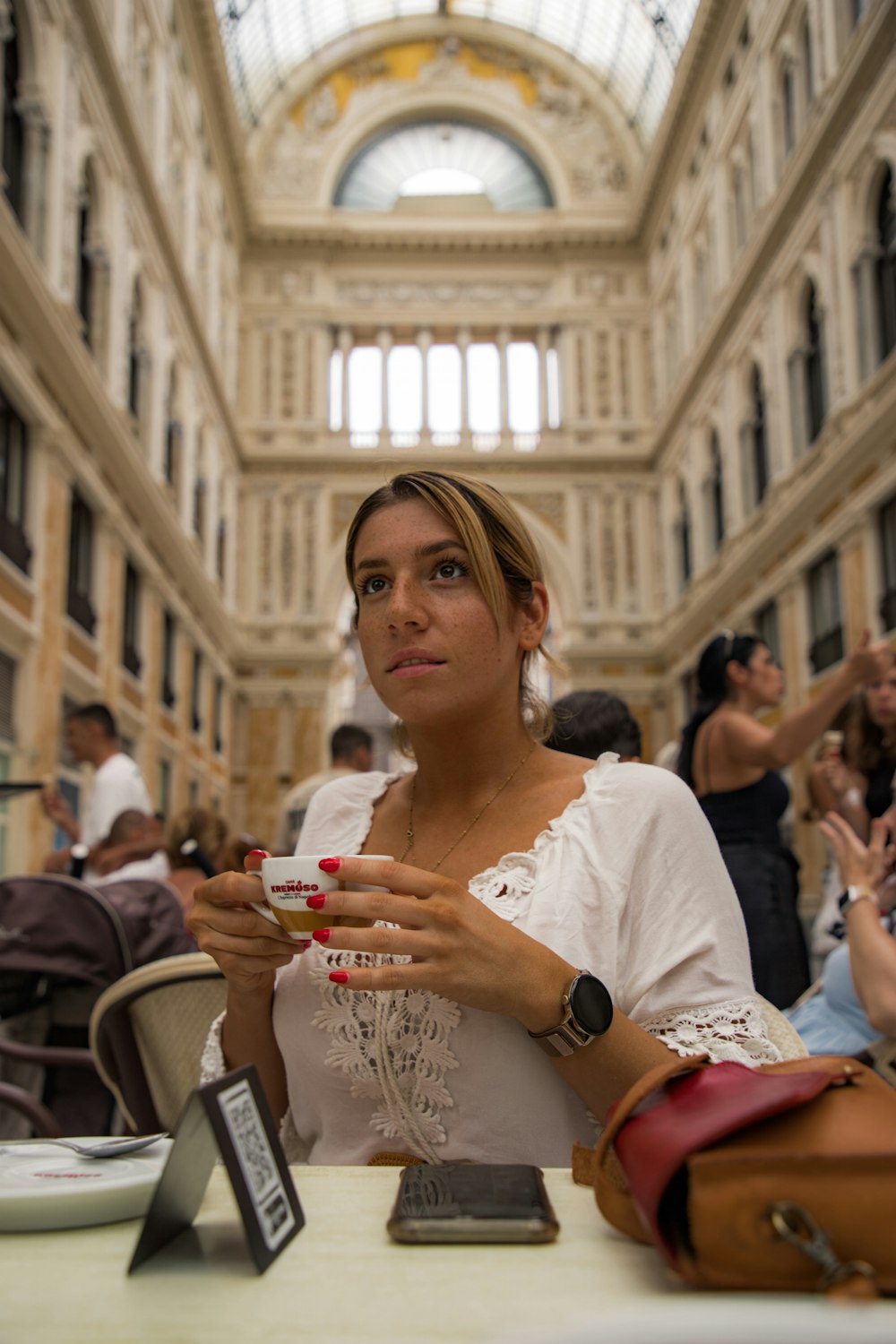a woman sitting at a table with a cell phone