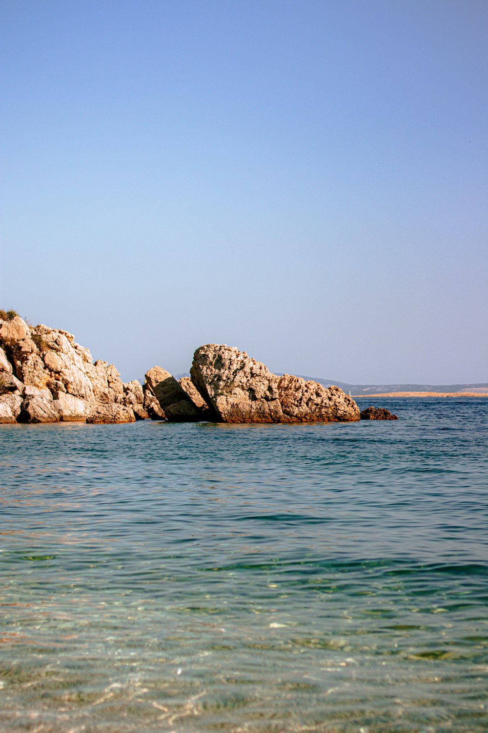 a large rock outcropping in the middle of a body of water