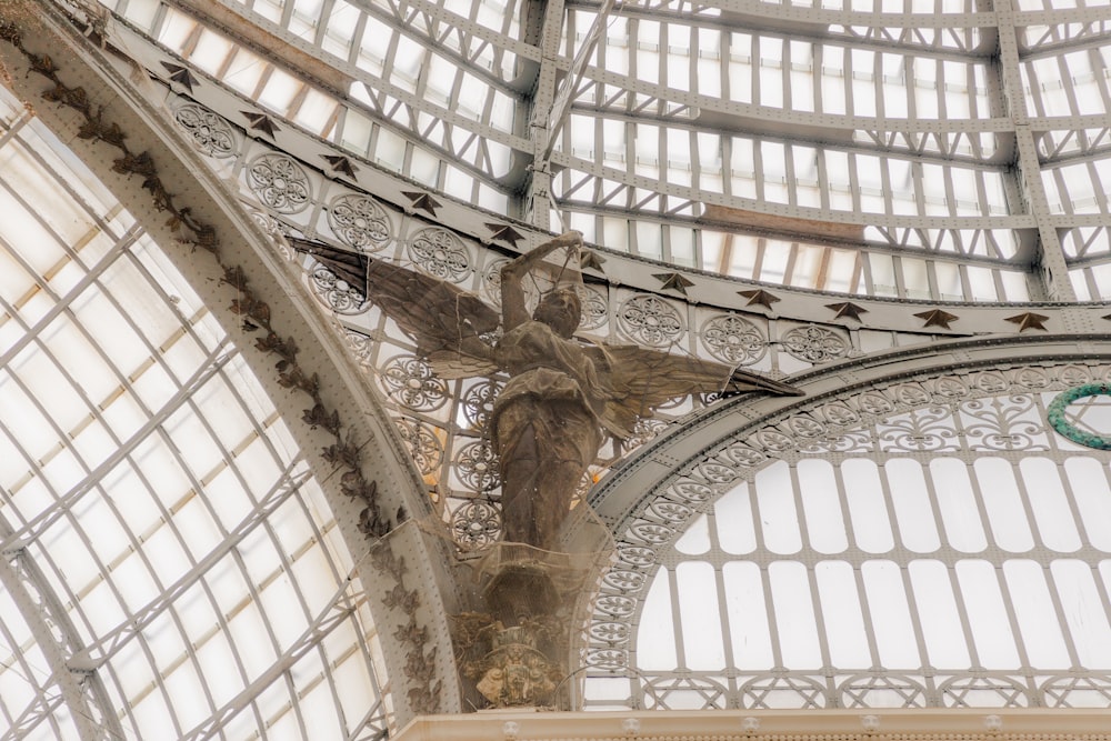a statue of an angel on the ceiling of a building
