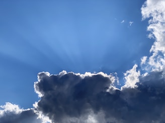 A stormy sky clearing to reveal sunlight, representing hope after struggle.