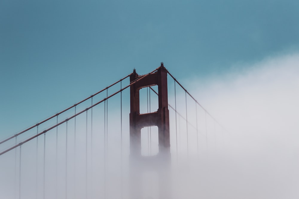 the golden gate bridge in the fog on a sunny day