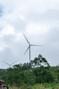 Technicians installing wind turbines on a breezy hilltop.