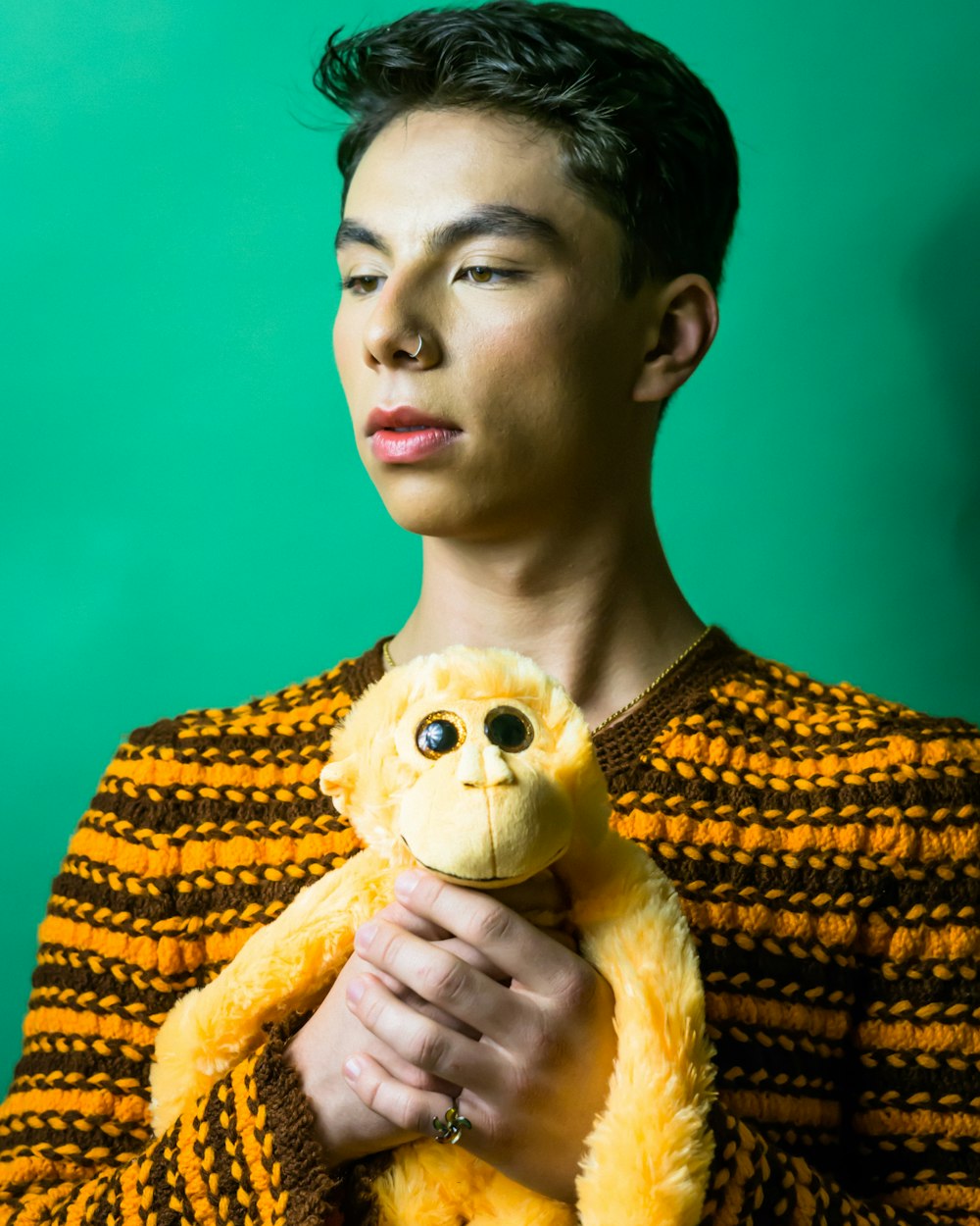 a young man holding a yellow teddy bear