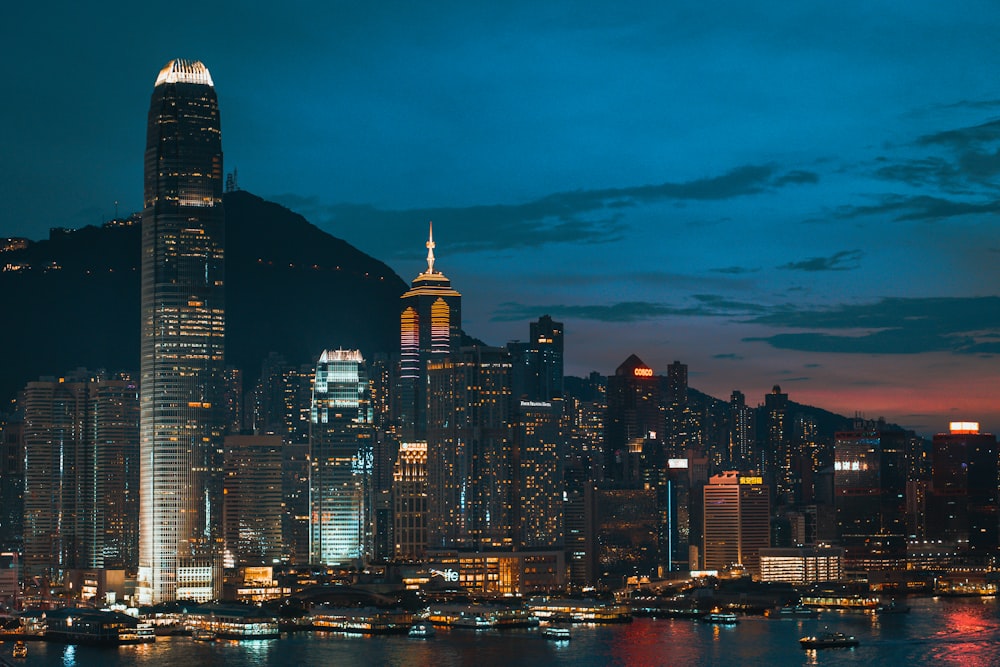 a city skyline at night with a mountain in the background