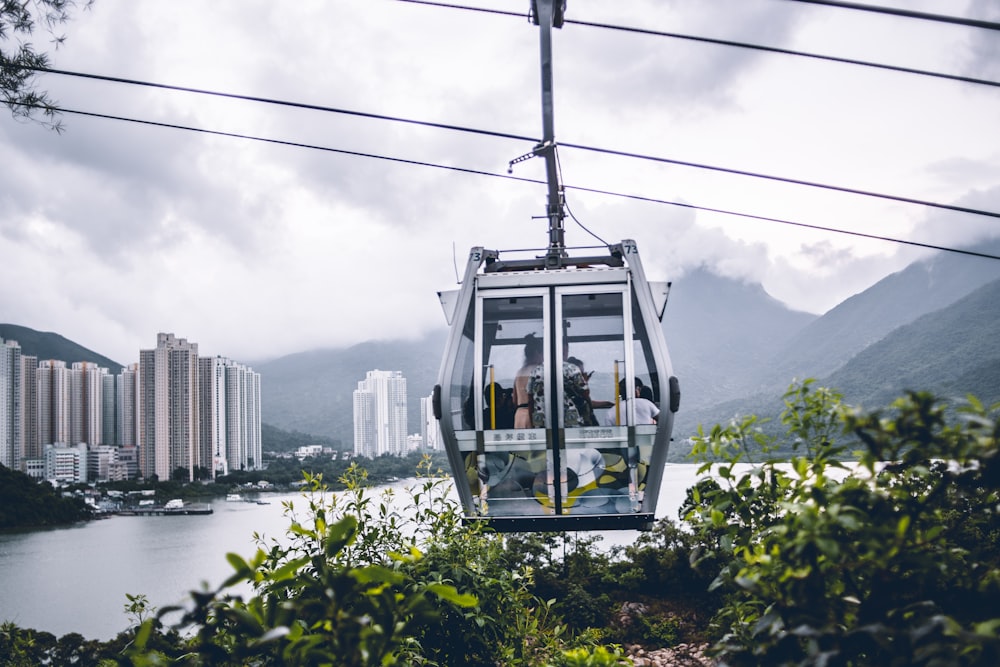 a cable car with people on it going over a river