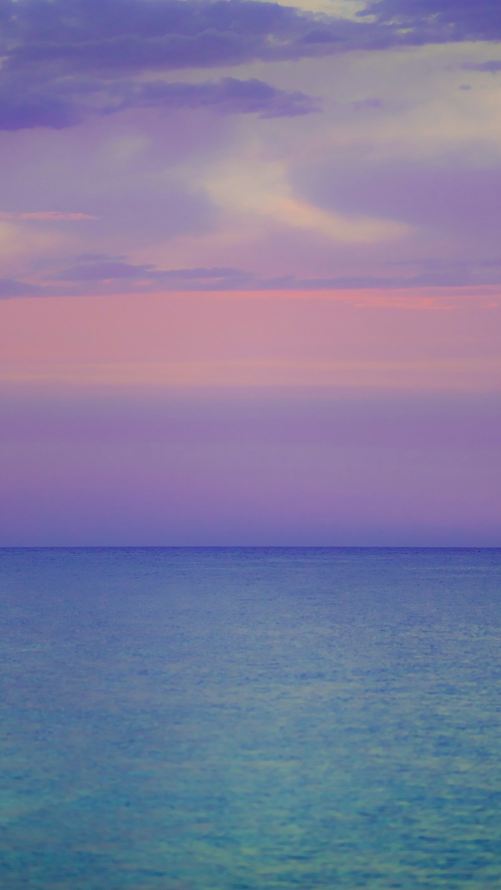 a large body of water sitting under a purple sky