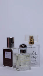 Three perfume bottles lined up showcasing different scent layers for stacking.