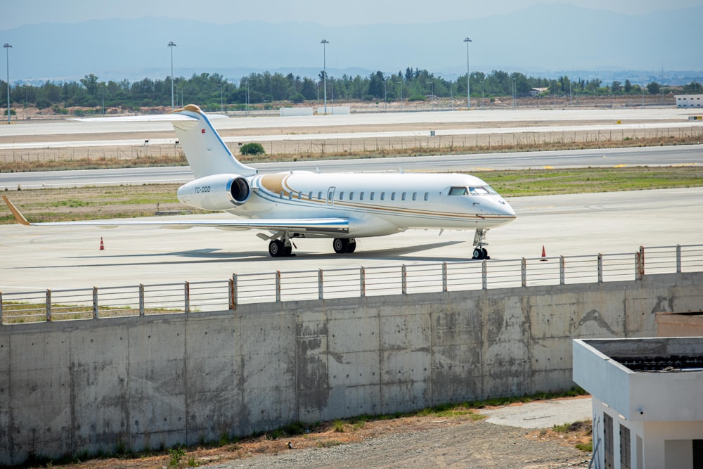 a white and blue plane is on a runway