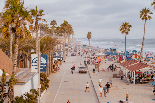A vibrant beach scene at Boca del Río with new commercial modules bustling with tourists and local vendors.