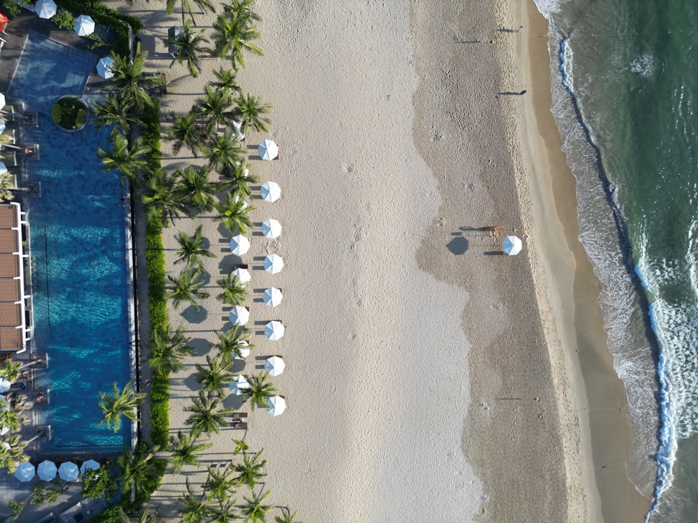 an aerial view of a beach with chairs and umbrellas