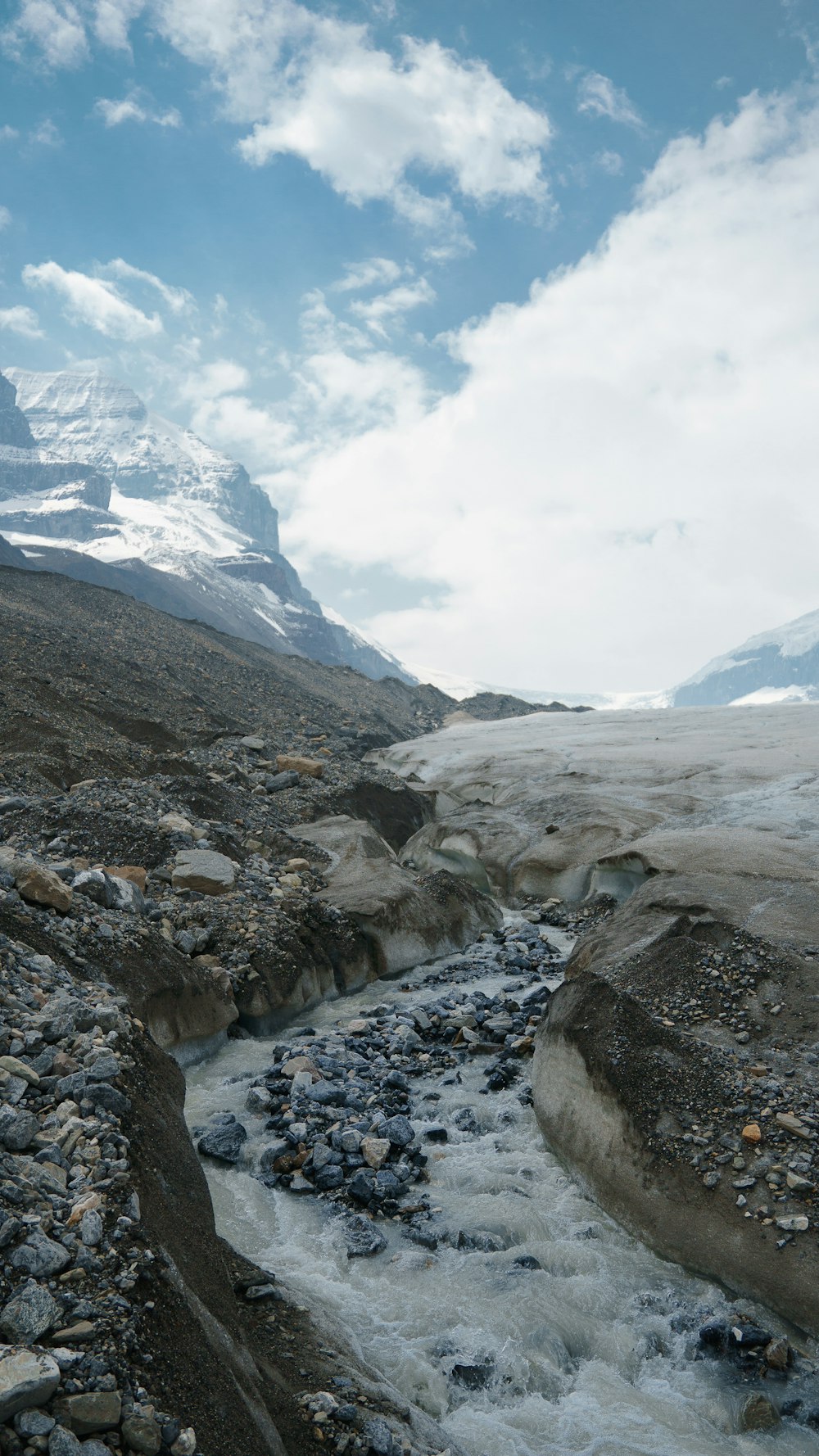 a stream of water running through a rocky valley