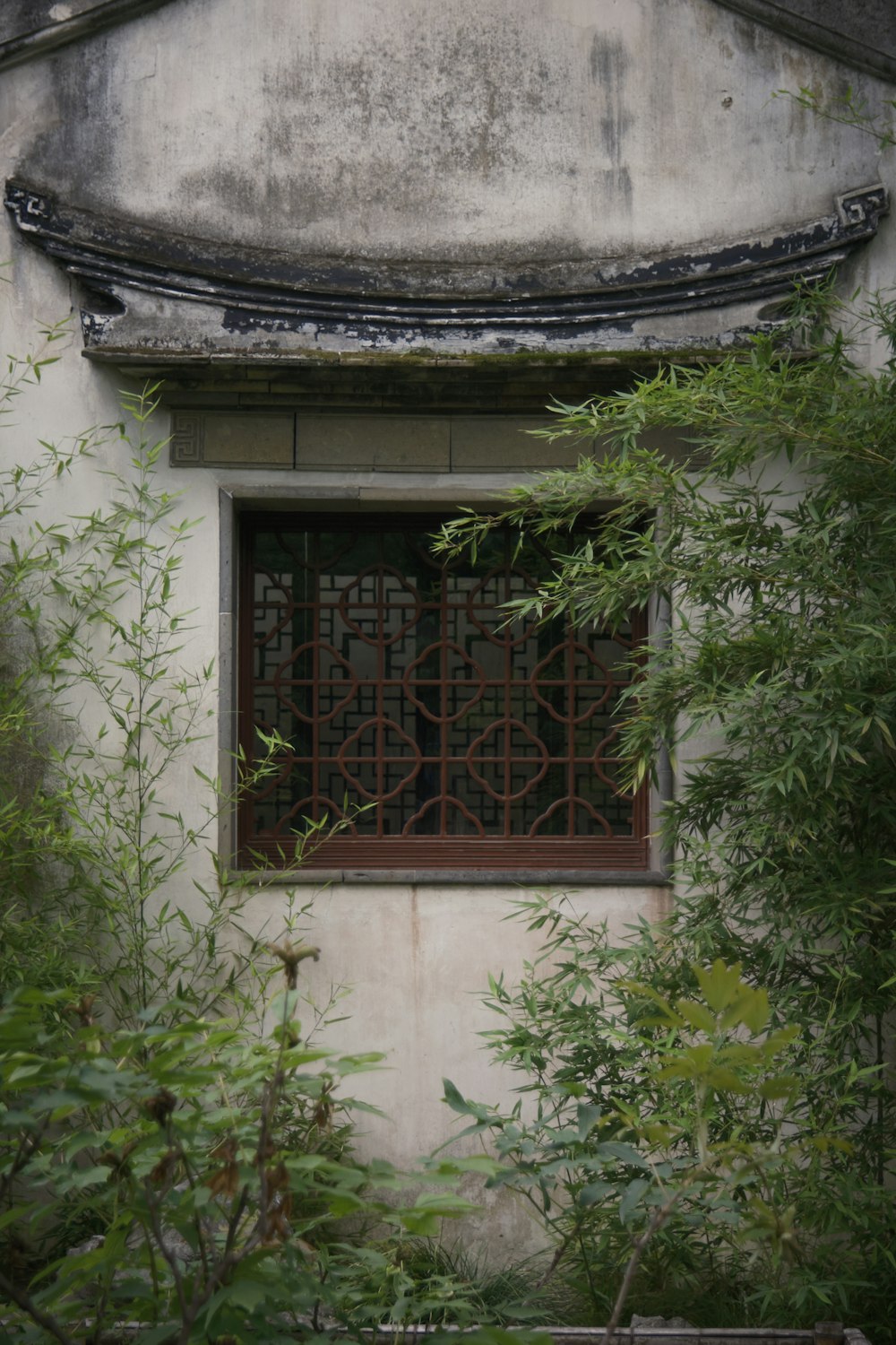 ein Gebäude mit einem Fenster und einer Bank davor