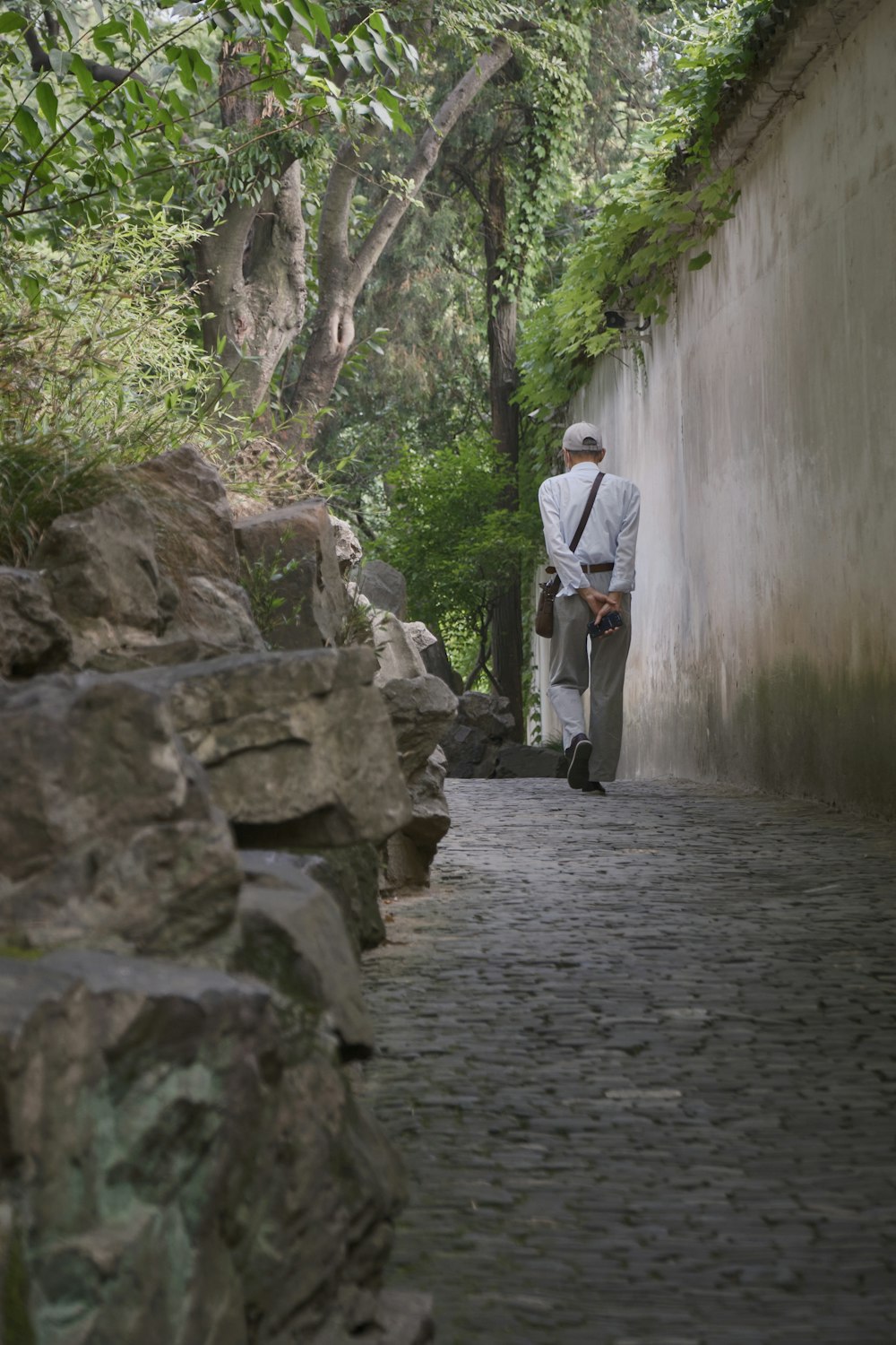 a man is walking down a cobblestone street