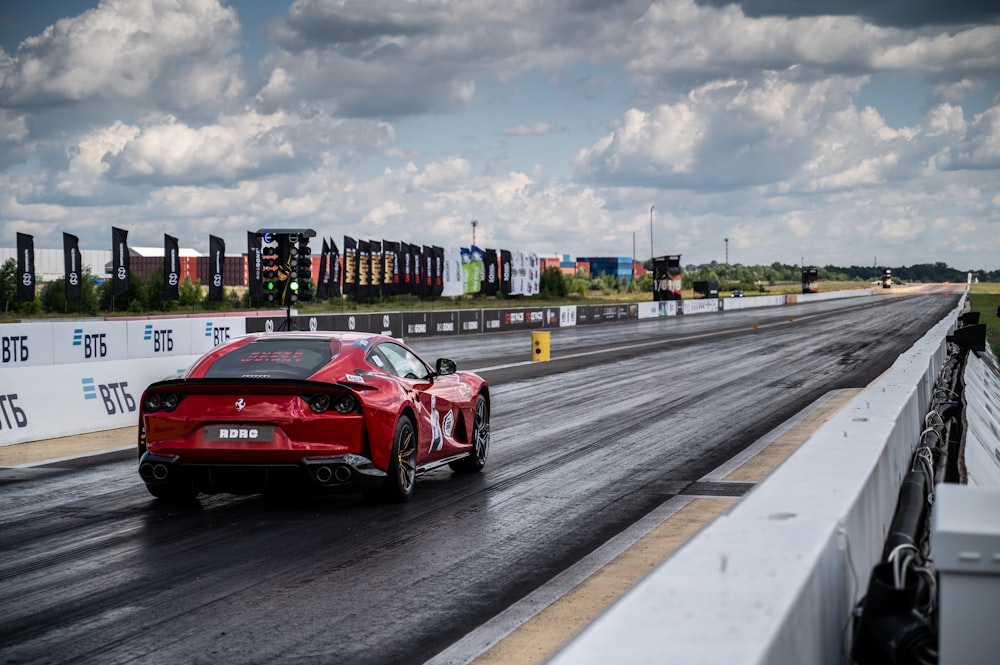 a red sports car driving down a race track