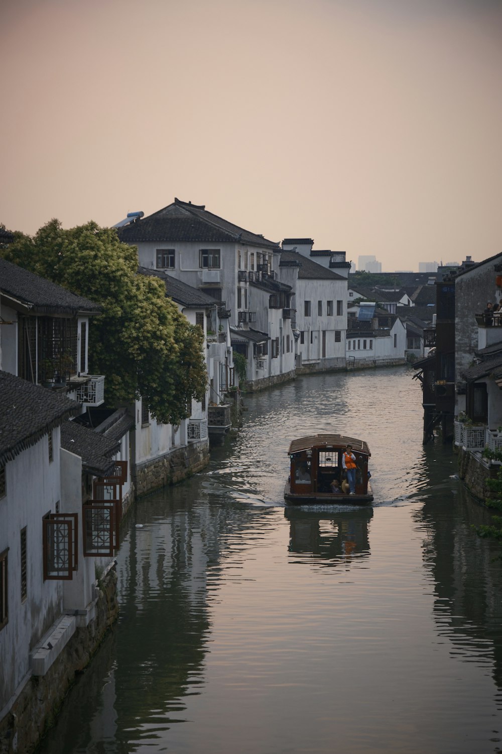 a boat traveling down a river next to a row of houses