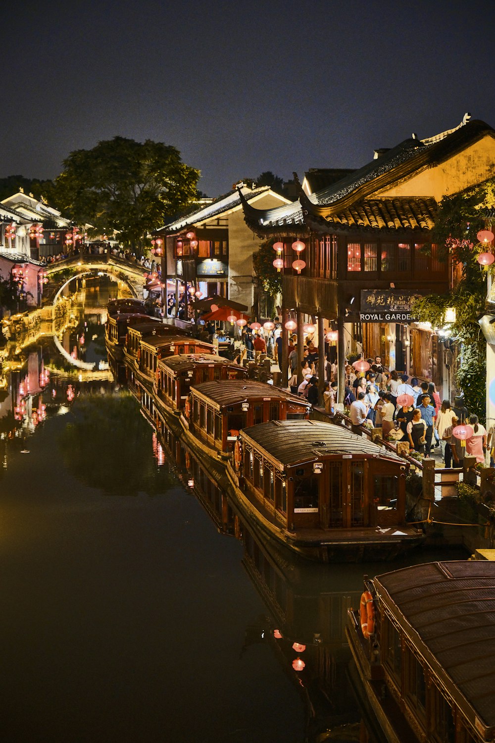 a river filled with lots of boats next to tall buildings