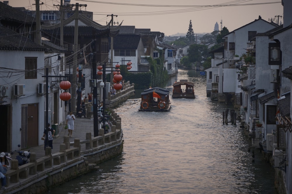 a boat traveling down a river next to tall buildings