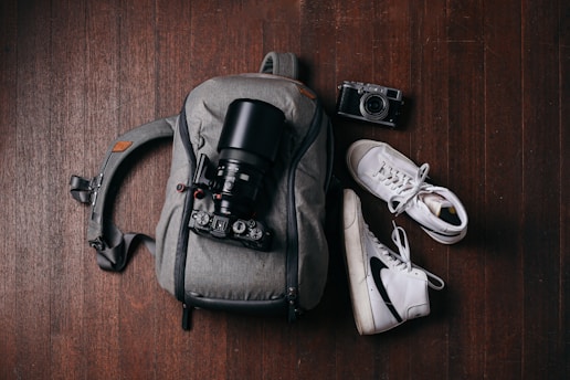 a camera and some shoes on a wooden floor