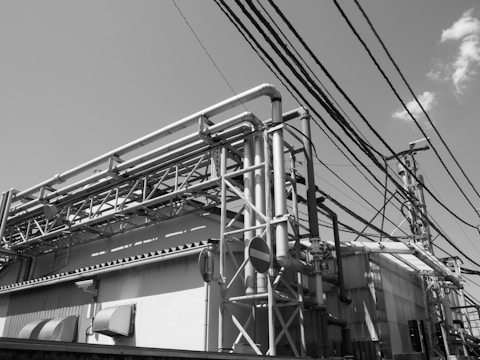 A minimalist black-and-white photo of a busy industrial site with workers.