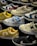 A variety of sneakers are displayed, showcasing different brands and color schemes. Prominent brands featured include Nike and New Balance. The shoes are arranged closely together, highlighting their unique design elements such as logos and color accents.