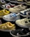 A variety of sneakers are displayed, showcasing different brands and color schemes. Prominent brands featured include Nike and New Balance. The shoes are arranged closely together, highlighting their unique design elements such as logos and color accents.
