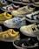 A variety of sneakers are displayed, showcasing different brands and color schemes. Prominent brands featured include Nike and New Balance. The shoes are arranged closely together, highlighting their unique design elements such as logos and color accents.