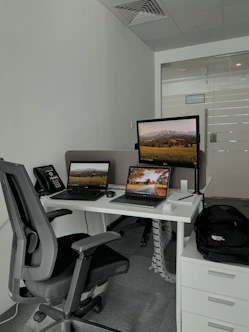 A professional office desk with a laptop, phone, and headset ready for customer support.