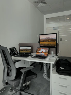 A professional office desk with a laptop, phone, and headset ready for customer support.