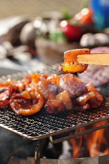 Close-up of sizzling marinated Korean BBQ meat grilling over an open flame at a modern table grill.