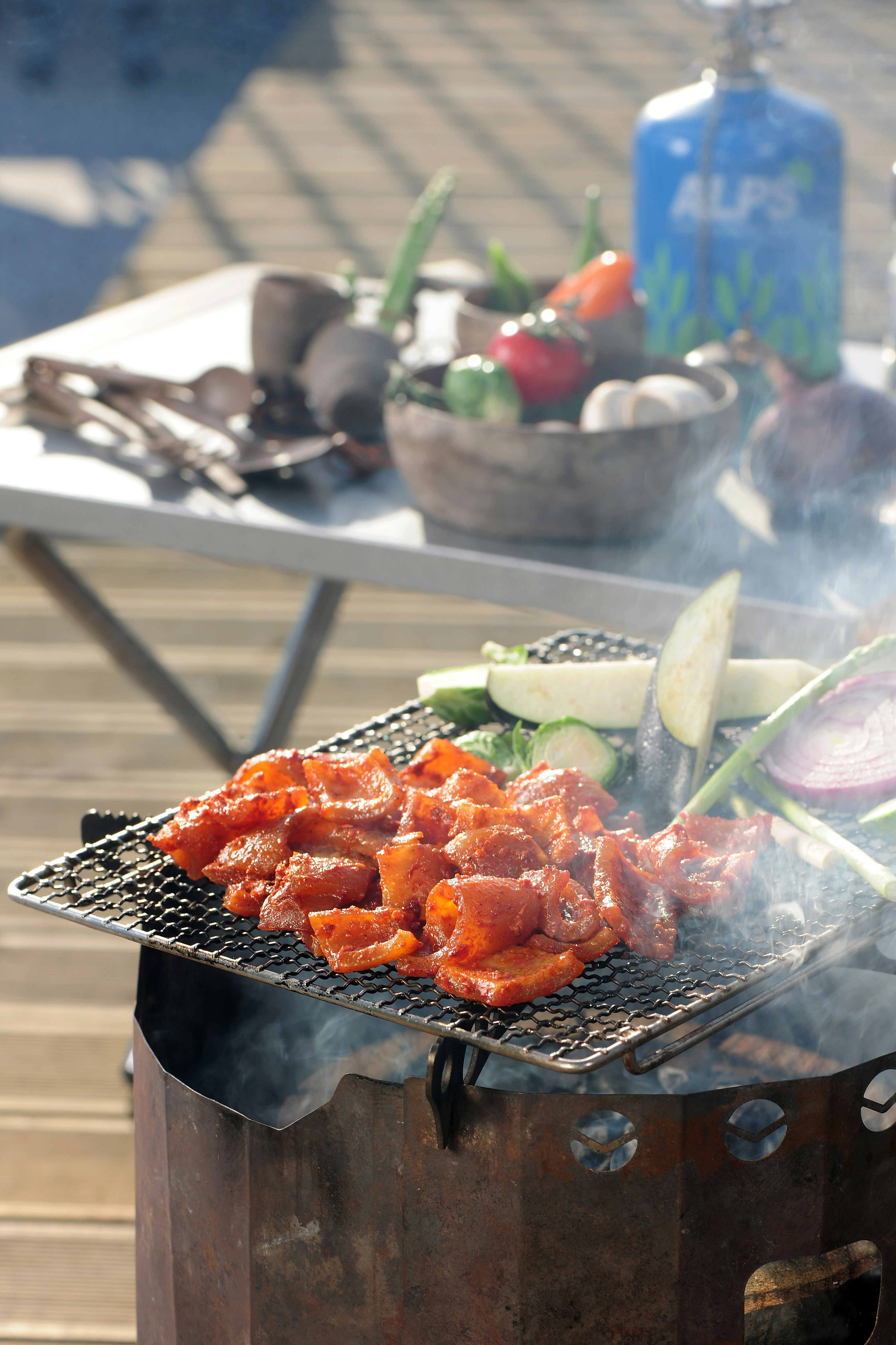 a bbq grill with vegetables and meat cooking on it