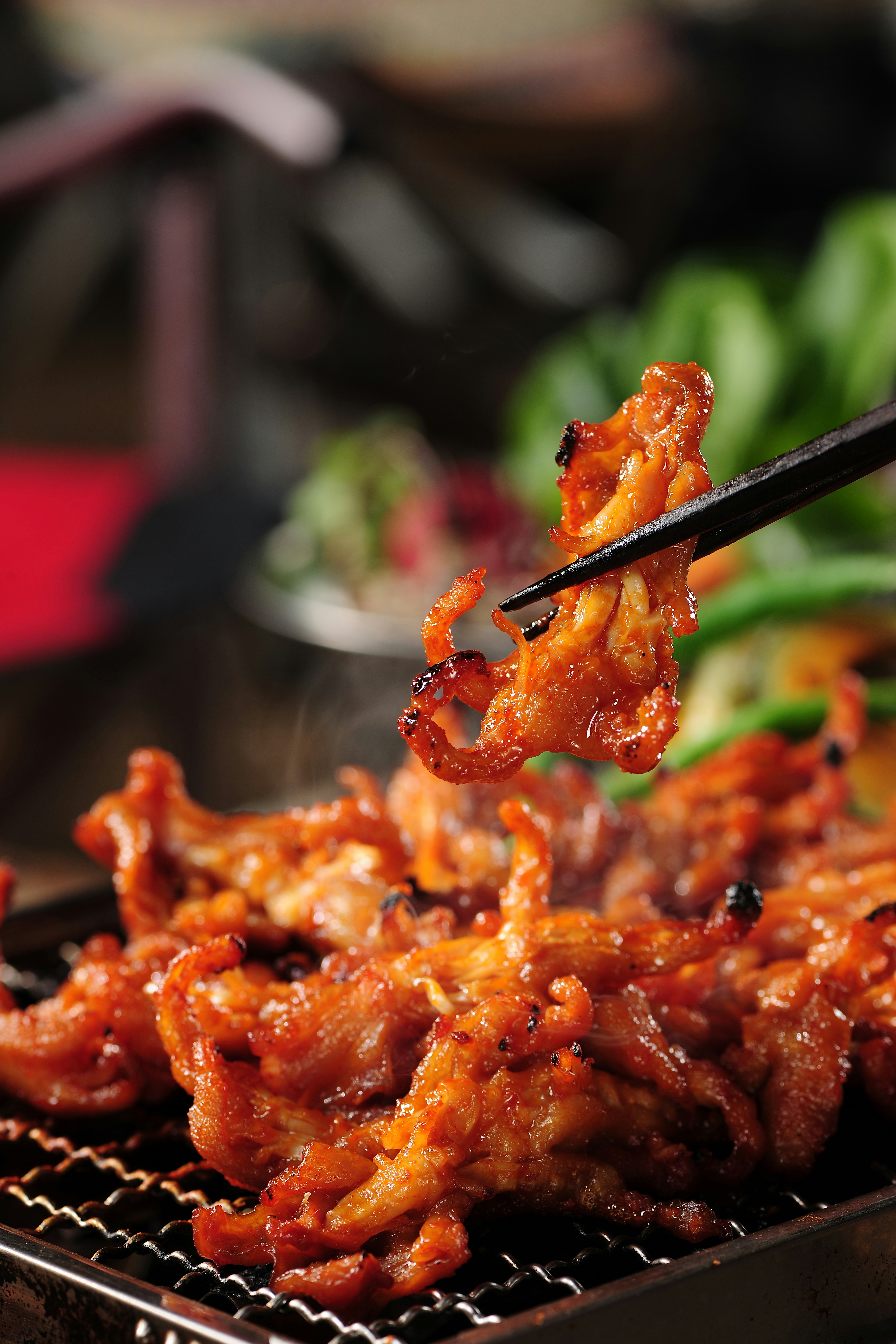 a close up of a person holding chopsticks over some food