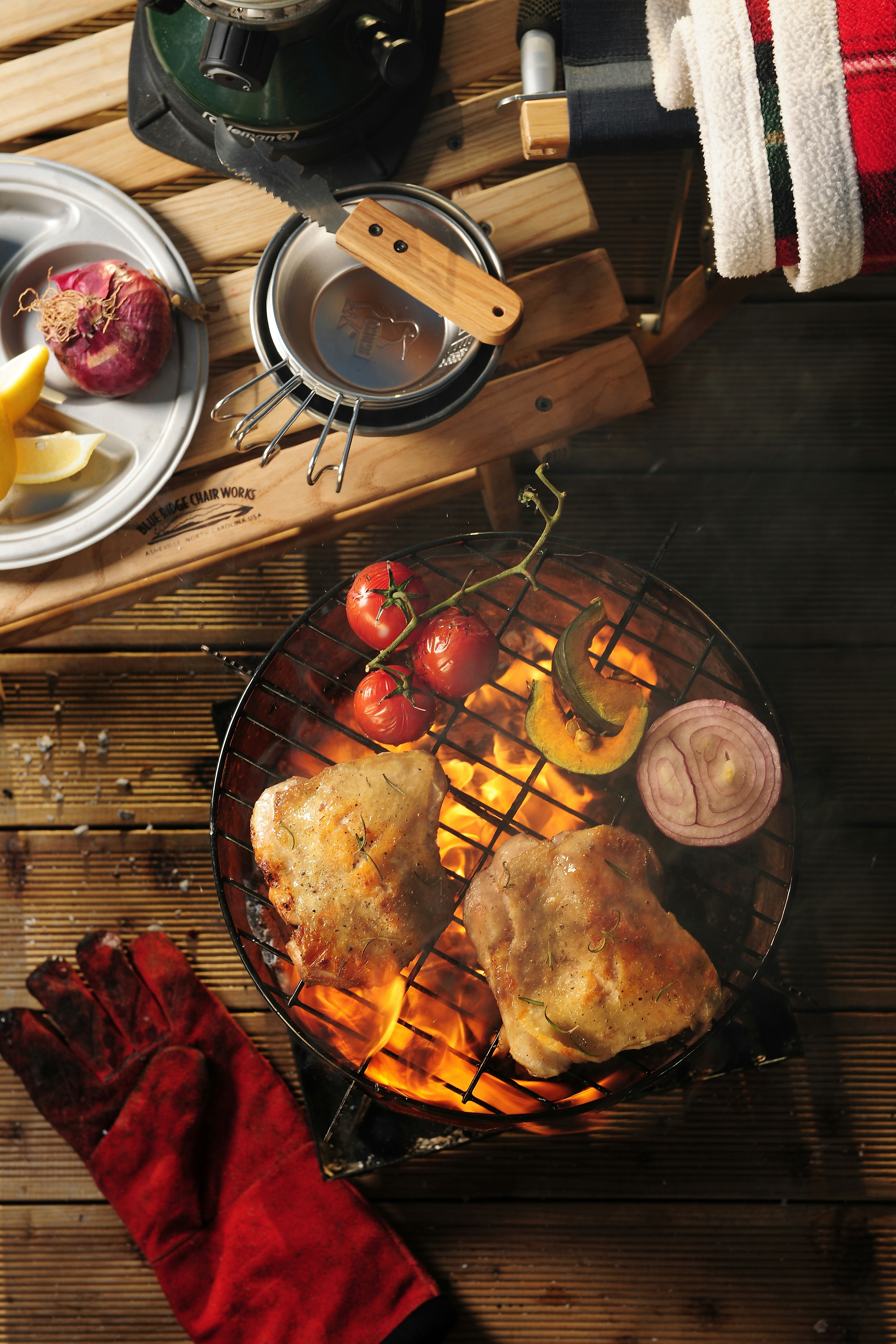 a bbq with chicken, tomatoes and onions on it