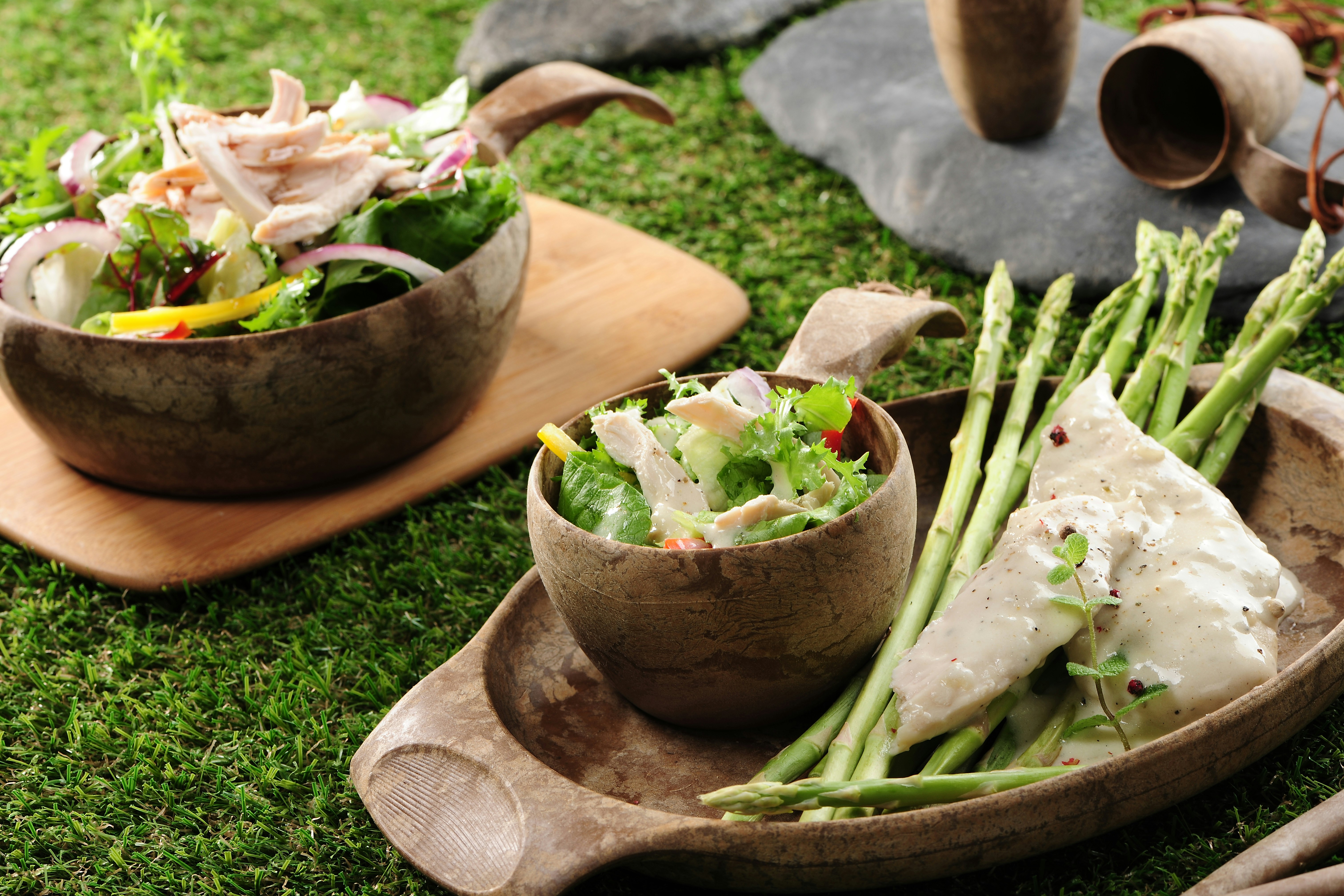 a couple of bowls filled with food on top of a green field