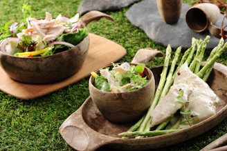 a couple of bowls filled with food on top of a green field