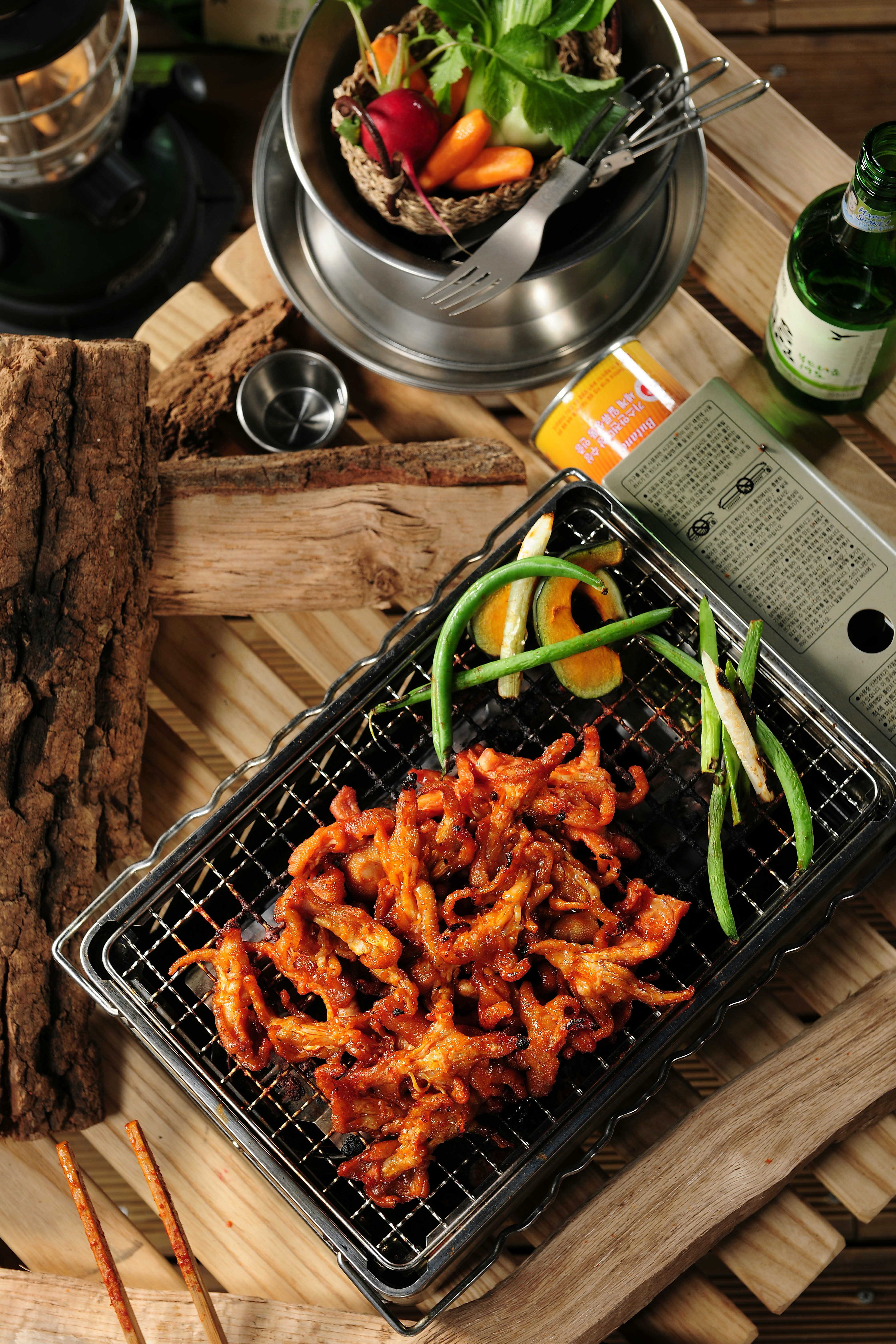 a bbq with meat and vegetables on a wooden table