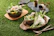 A rustic table setting featuring colorful stoneware plates stacked with fresh fruit and flowers.