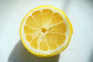 Lemon pickle chunks bursting with zesty juice, shot with fiery red accents and moody lighting.