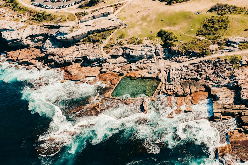 an aerial view of a rocky coastline with a body of water