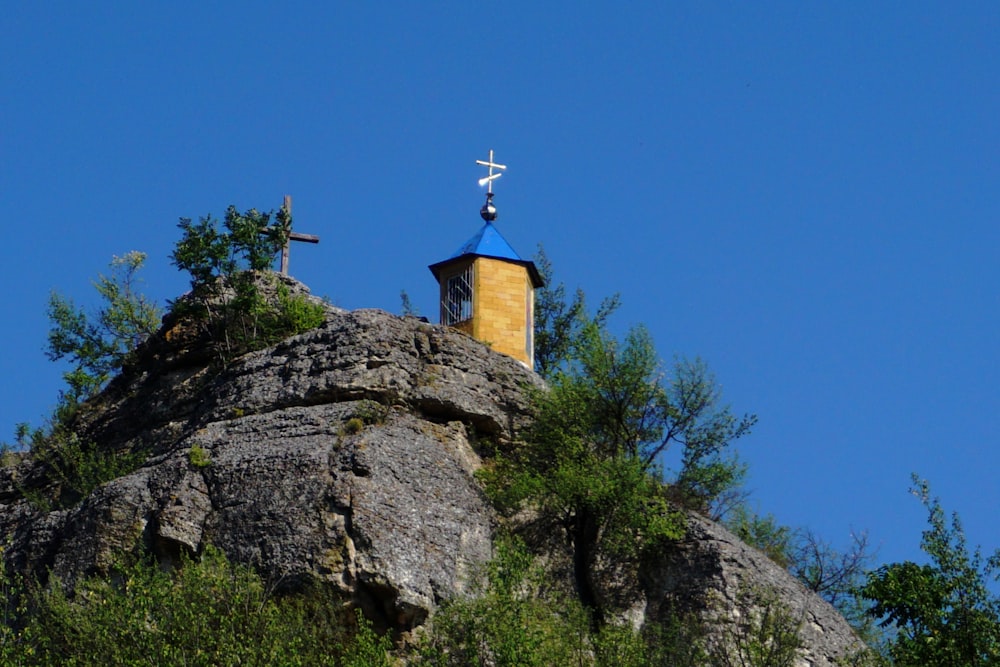 a church on top of a rock with a cross on it