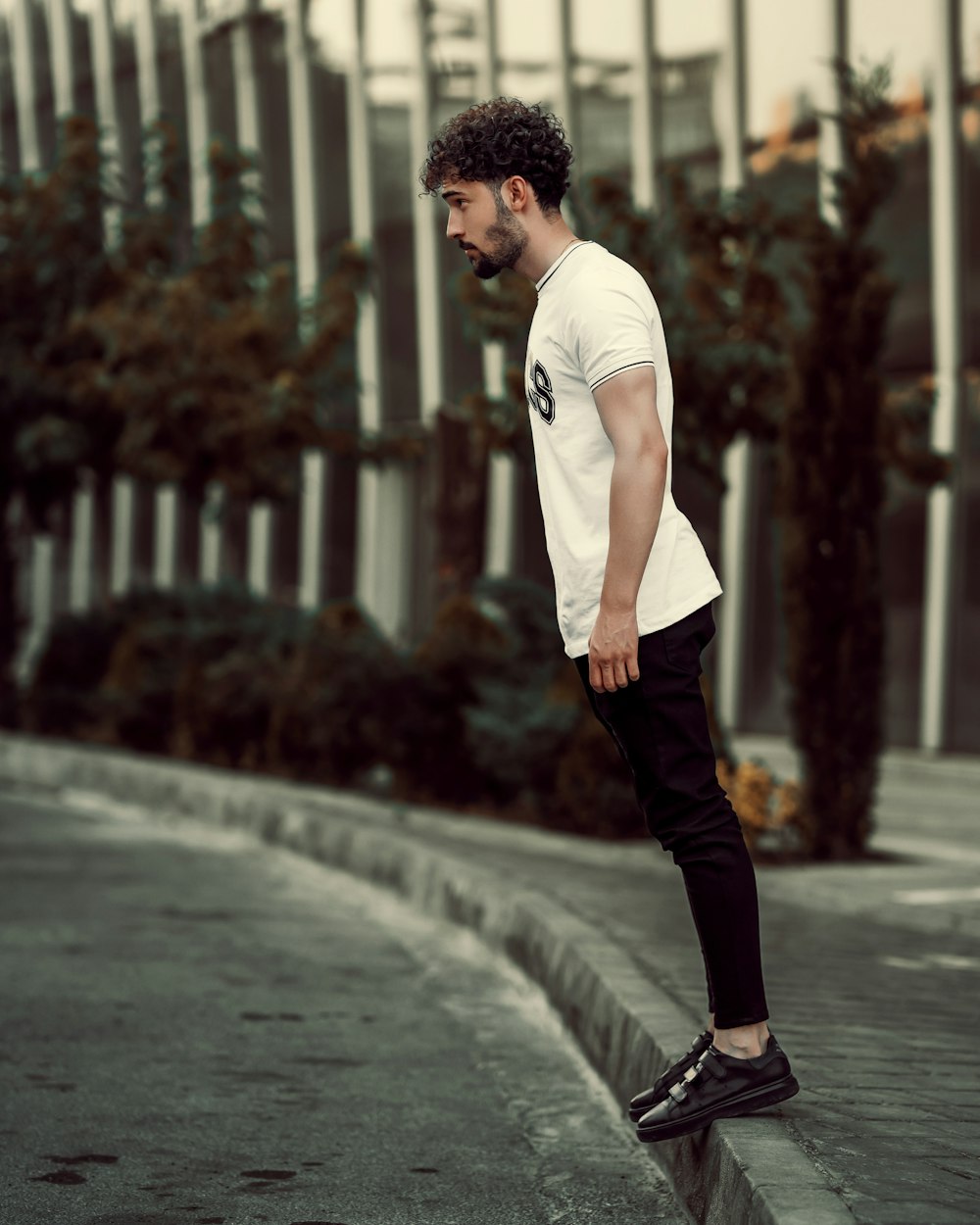 a man in white shirt and black pants skateboarding