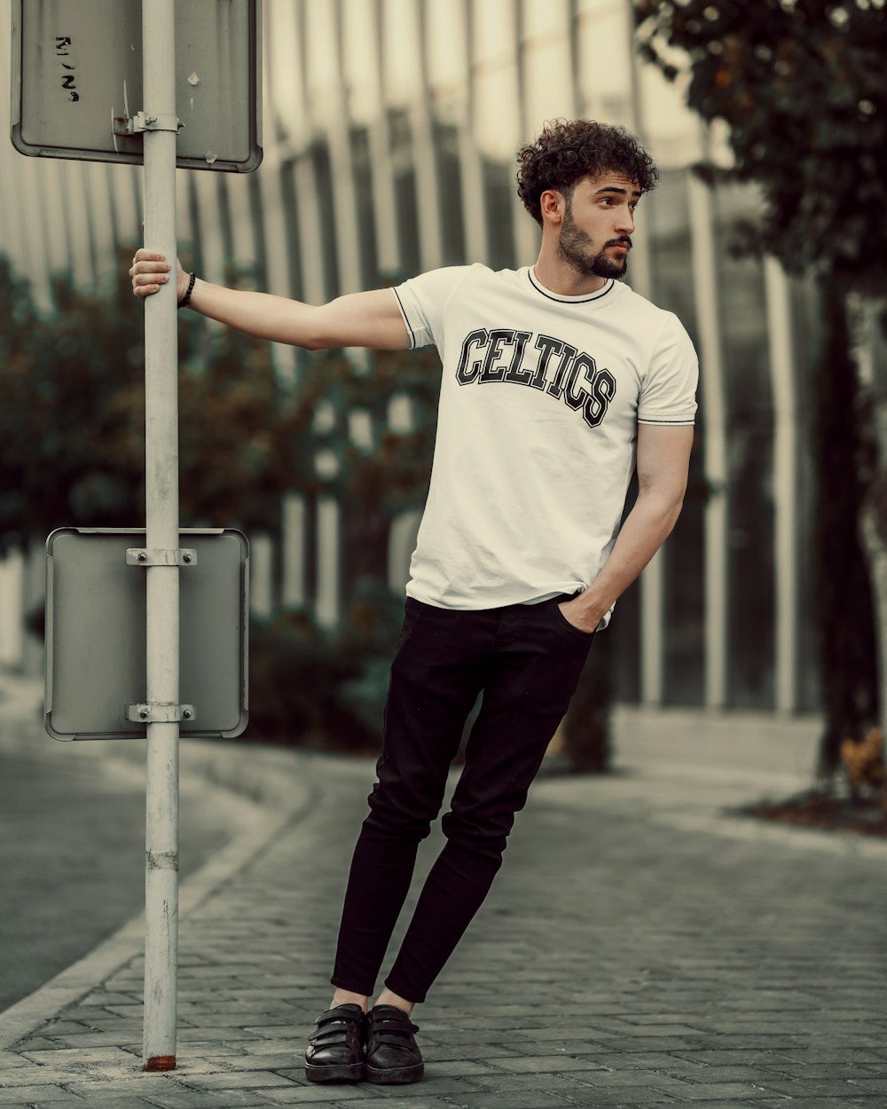 a man standing next to a street sign