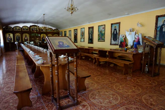 A cozy corner with an embroidered Orthodox icon hanging above a wooden table set for tea.